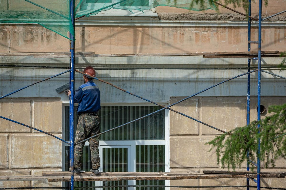 Práca na fasáde domu z lešenia