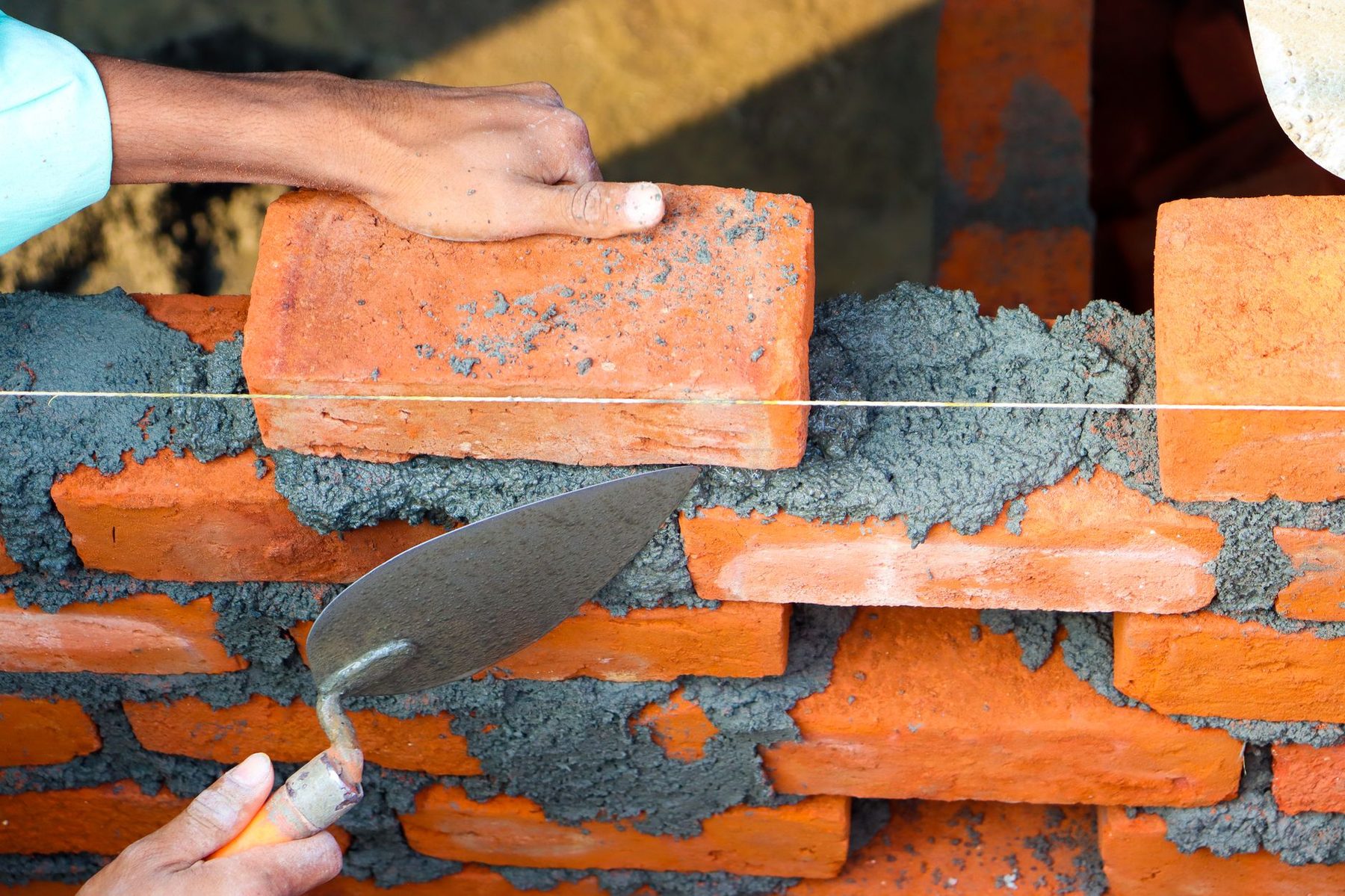 Murárske práce — kladenie tehál a malty na stavbe IČ-building